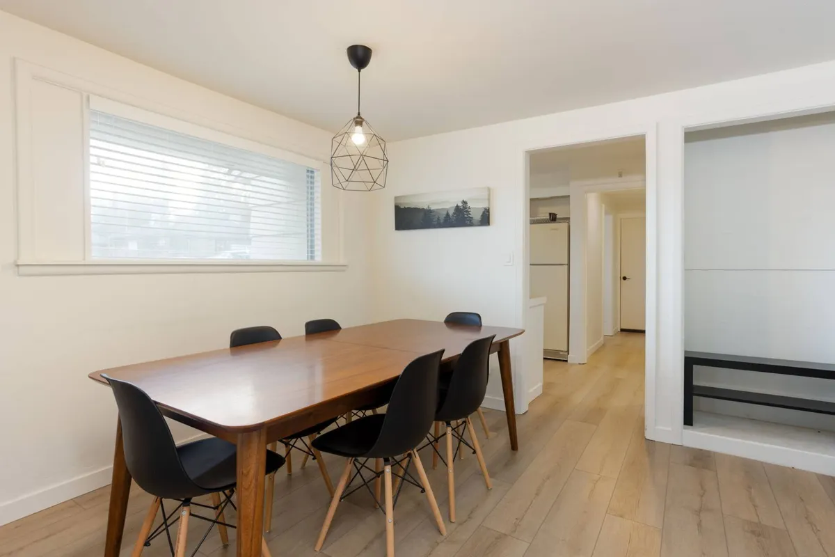 A warm and welcoming dining area featuring a well-set table, comfortable chairs, a modern light fixture, and art on the wall. The ambiance is perfect for family meals or entertaining guests, reinforcing the sense of connection and celebration.