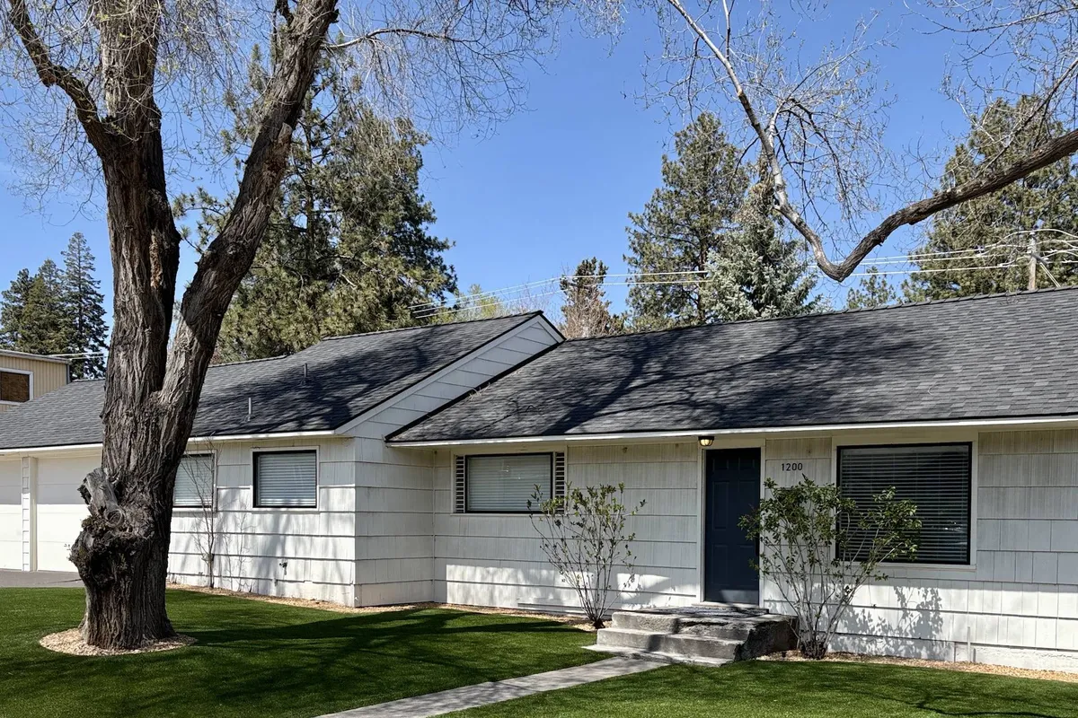 This image features a spacious front porch shaded by a large tree, overlooking a lush green lawn—an ideal spot for family gatherings, outdoor relaxation, and playing in the yard.
